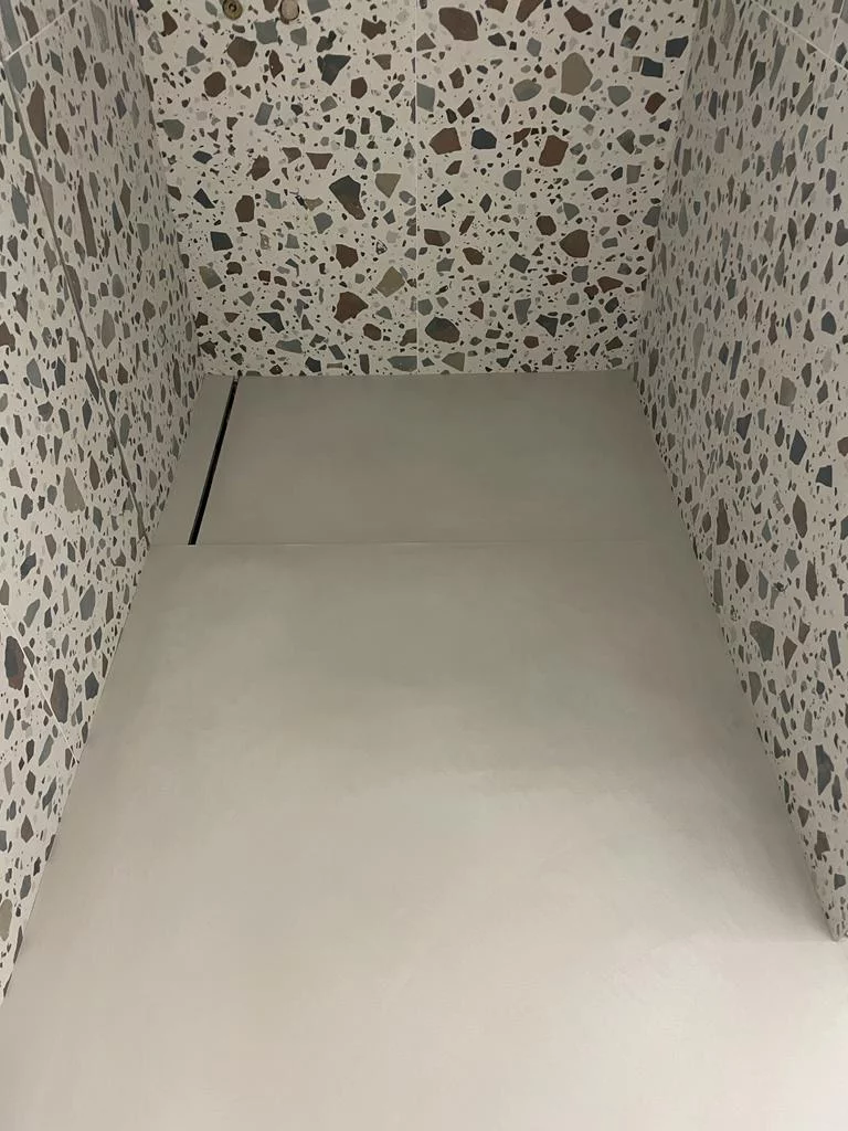 nowoczesna łazienka z lastryko na ścianie i jasnym mikrocementem na podłodze